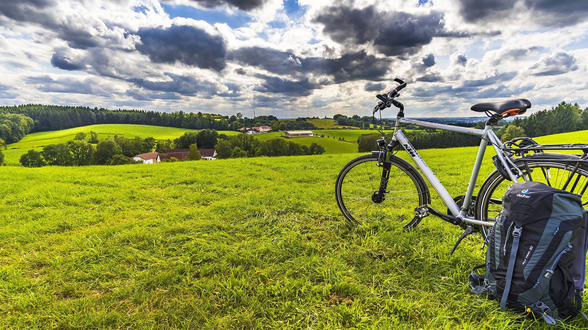 Rad und Rucksack auf einer Wiese mit blauem Himmel