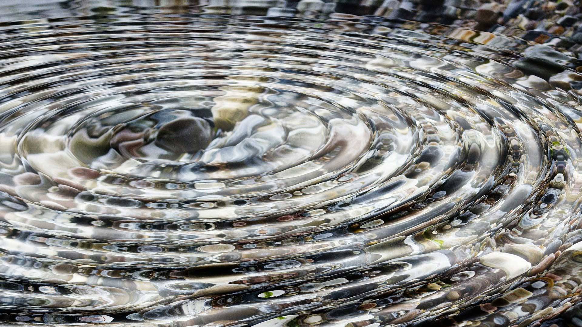 Stein der ins Wasser fällt und Wellen wirft